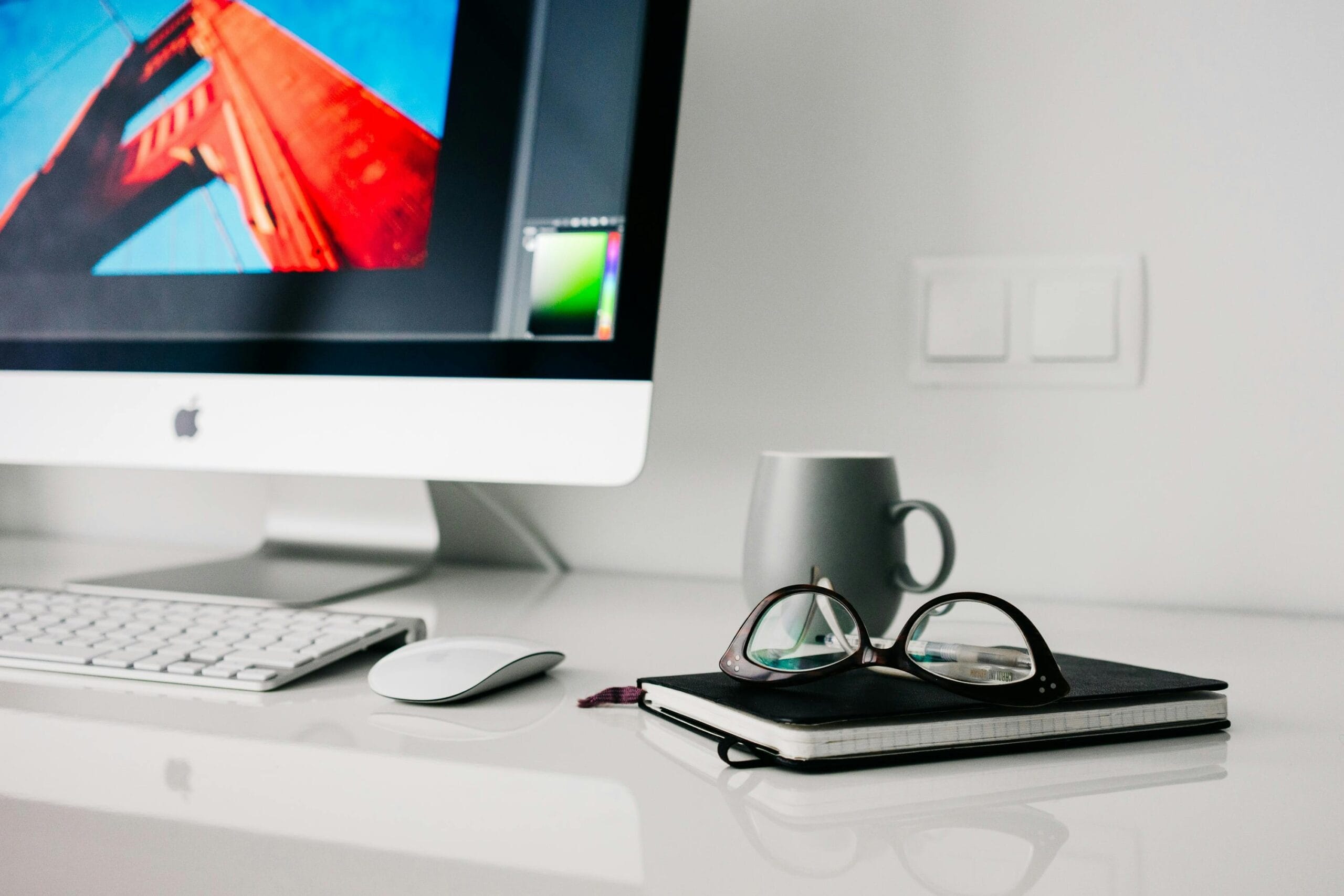 Modern workspace with a desktop computer, tablet and notebook, representing technology strategy planning for SMEs.